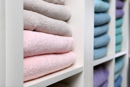 Colorful towels on shelves, closeup. bathroom suppliesの写真素材