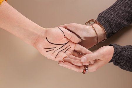 Chiromancer reading lines on woman's palm against color background, top viewの写真素材