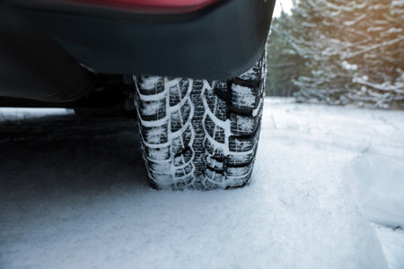 Modern car on snowy road in winter forest, closeup. Space for textの写真素材