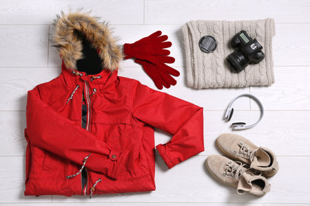 Flat lay composition with warm clothes for winter vacation on wooden backgroundの写真素材
