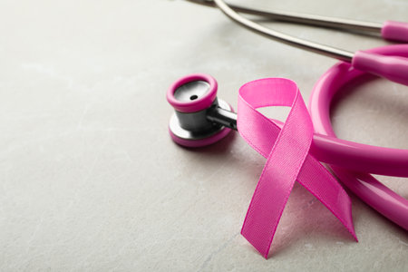Pink ribbon and stethoscope on gray background, space for text. breast cancer conceptの写真素材