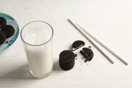 Glass of milk with chocolate cookies on wooden background, space for textの写真素材