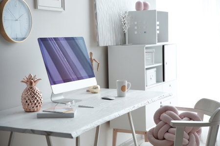 Contemporary workplace with computer on table near white wall. interior designの写真素材