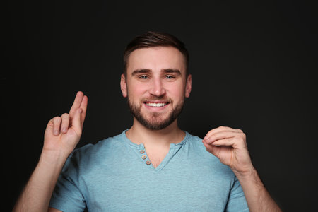 Man using sign language on black backgroundの写真素材