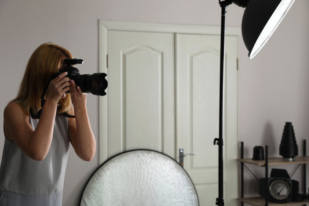 Young woman with professional camera in photo studioの写真素材