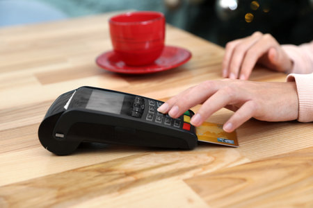 Woman using card machine for non cash payment at table, closeupの写真素材