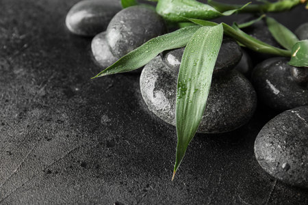 Zen stones and bamboo leaves on black background, closeup. Space for textの写真素材