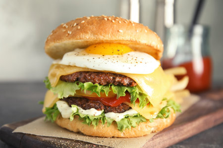 Tasty burger with fried egg on wooden boardの写真素材