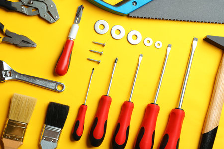 Flat lay composition with construction tools on color background