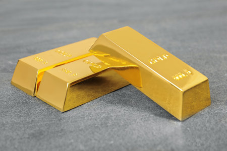 Three shiny gold bars on gray table