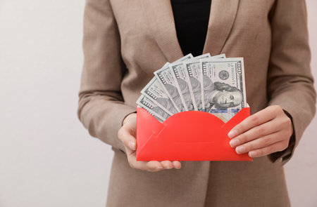 Woman holding envelope with dollar bills on white background, closeupの写真素材