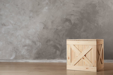 Wooden crate on floor against color background, space for textの写真素材