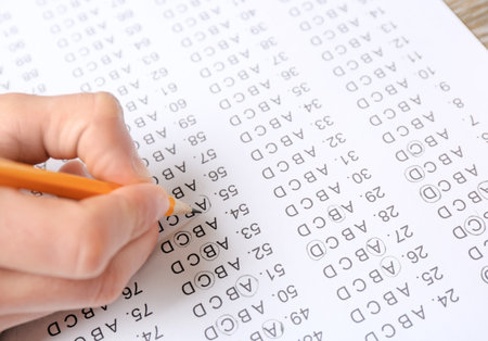 Student filling answer sheet at table, closeupの写真素材