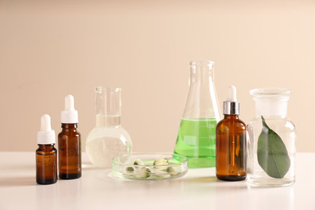 Skin care products, ingredients and laboratory glassware on table. Dermatology researchの写真素材
