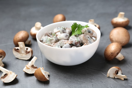 Bowl of fried mushrooms with sauce on gray tableの写真素材