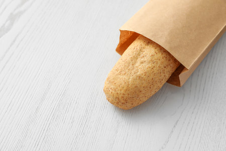 Baguette in paper bag on wooden table. Space for textの写真素材