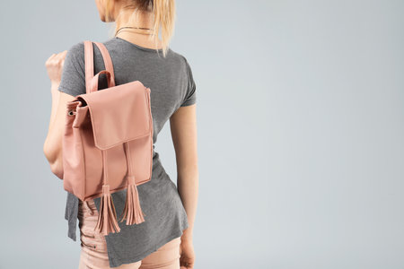 Woman with stylish backpack on gray background. Space for textの写真素材