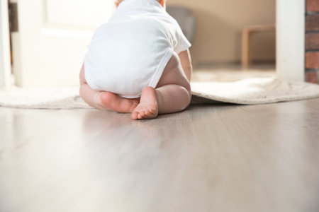 Cute little baby crawling on floor indoors, closeupの写真素材
