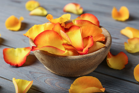 Bowl with rose petals on wooden backgroundの写真素材
