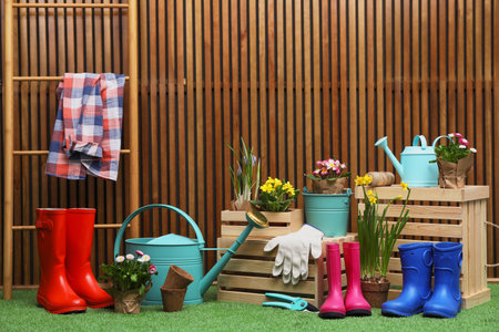 Composition with different gardening tools on artificial grass at wooden wall. Space for textの写真素材