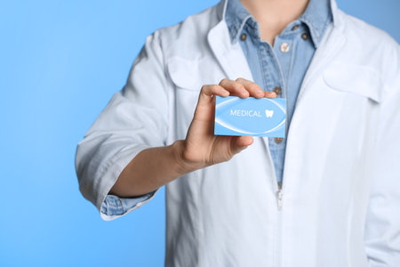 Doctor holding business card on color background, closeup with space for text. dental medical serviceの写真素材