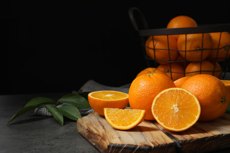 Wooden board with ripe oranges on table. Space for textの写真素材