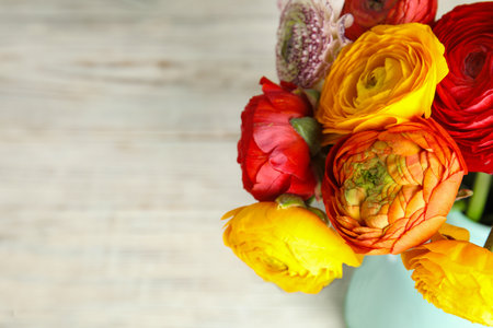 Bouquet of beautiful bright ranunculus flowers on light background. Space for text