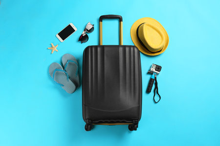 Flat lay composition with suitcase and traveler's accessories on color backgroundの写真素材