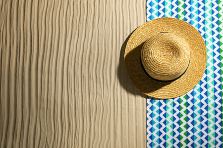 Bright towel and hat on sand, top view with space for text. beach objectsの写真素材