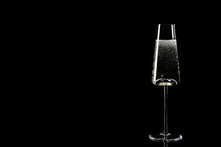 Glass of champagne on black background, space for textの写真素材