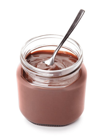 Glass jar with tasty chocolate cream and spoon isolated on whiteの写真素材