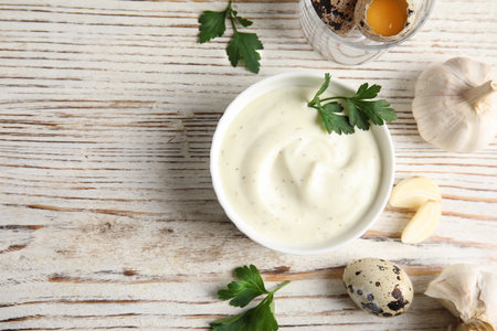 Flat lay composition with garlic sauce on wooden background. Space for textの写真素材