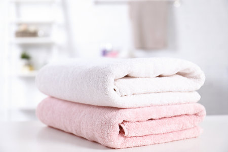 Stack of fresh towels on table in bathroomの写真素材