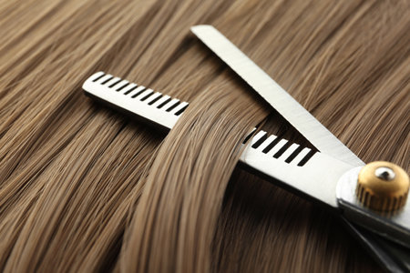 Thinning scissors on light brown hair, closeup. hairdresser serviceの写真素材