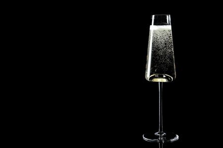 Glass of champagne on black background, space for textの写真素材