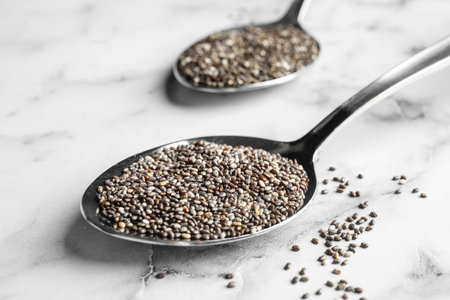 Spoon with chia seeds on marble background, closeupの写真素材