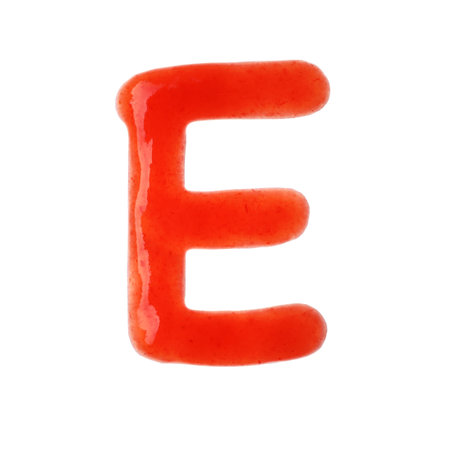 Letter E written with red sauce on white backgroundの写真素材