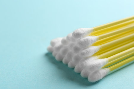 Pile of cotton swabs on color background, closeup. Space for textの写真素材