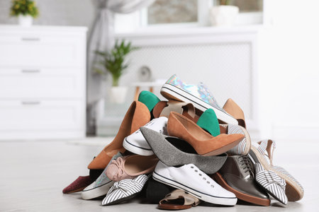 Pile of female shoes on floor indoorsの写真素材