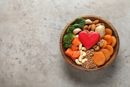 Bowl with heart-healthy products on gray background, top view. Space for textの写真素材