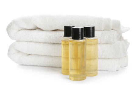 Mini bottles with cosmetic products and towels on white background. Hotel amenitiesの写真素材