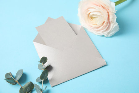 Beautiful ranunculus flower and envelope with card on color background. Space for textの写真素材