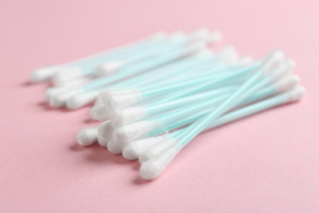 Pile of cotton swabs on color background, closeupの写真素材