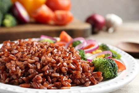 Plate of boiled brown rice with vegetables on table, closeupの写真素材