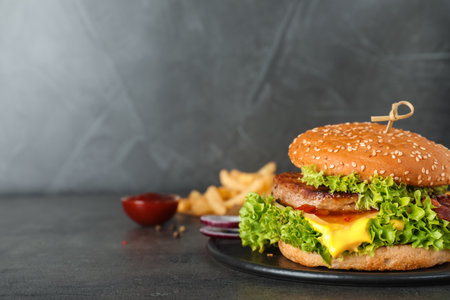 Plate with tasty burger on table. Space for textの写真素材