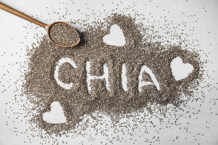 Spoon and word CHIA made of seeds on gray background, flat layの写真素材