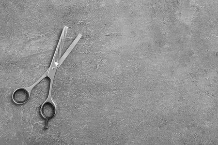 Thinning scissors and space for text on gray background, top view. hair dresser toolの写真素材