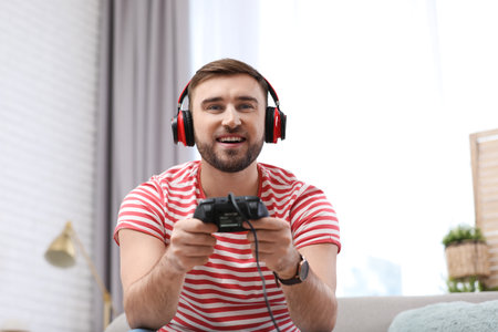 Young man playing video game at home