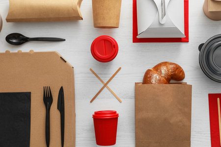 Flat lay composition with paper bag and different takeaway items on wooden background. space for designの写真素材