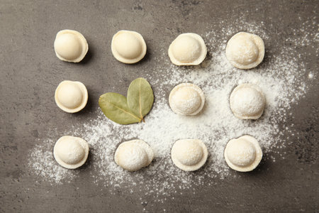 Flat lay composition with raw dumplings on gray background